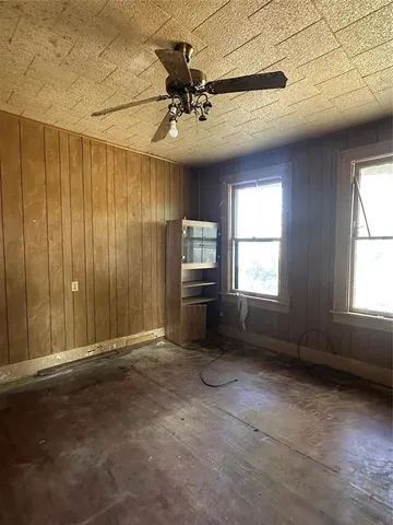 an empty room with windows and ceiling fan