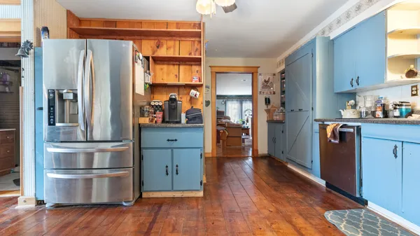 a kitchen with stainless steel appliances a refrigerator and wooden floor
