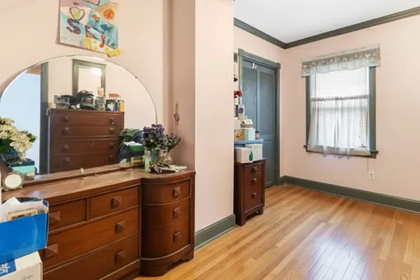 a view of a hallway with wooden floor and cabinet