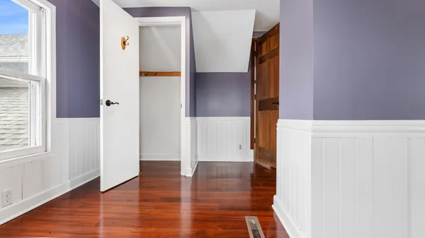 a view of a bedroom with wooden floor
