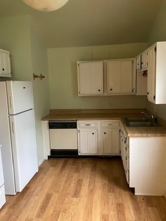a view of a hallway with wooden floor and a window