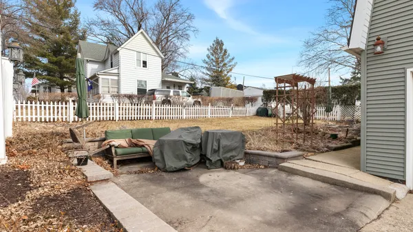 a view of a patio with couches and table and chairs and wooden fence