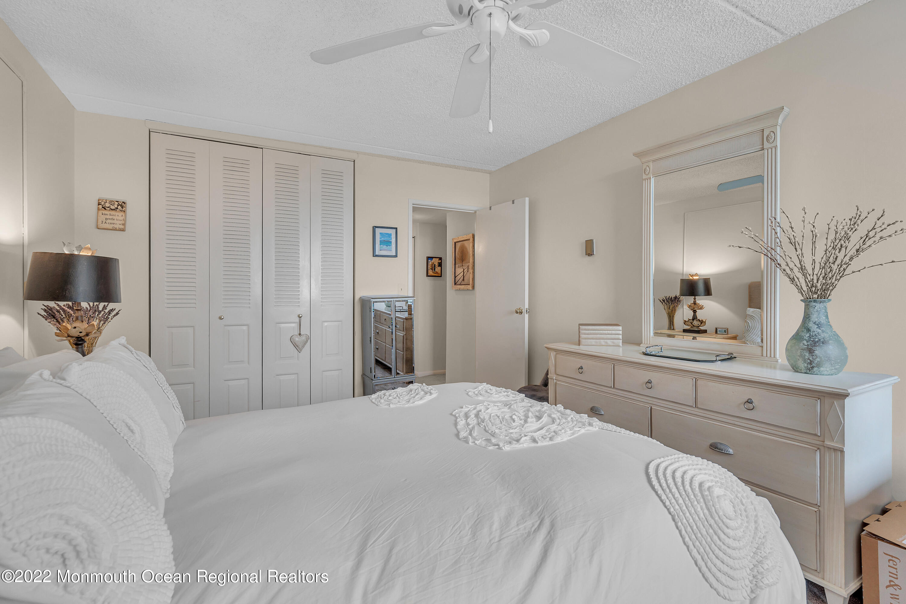 1000 River Road, Unit 7B Belmar, NJ 07719 - Photo 16 of 38 a bedroom with a bed and a chandelier