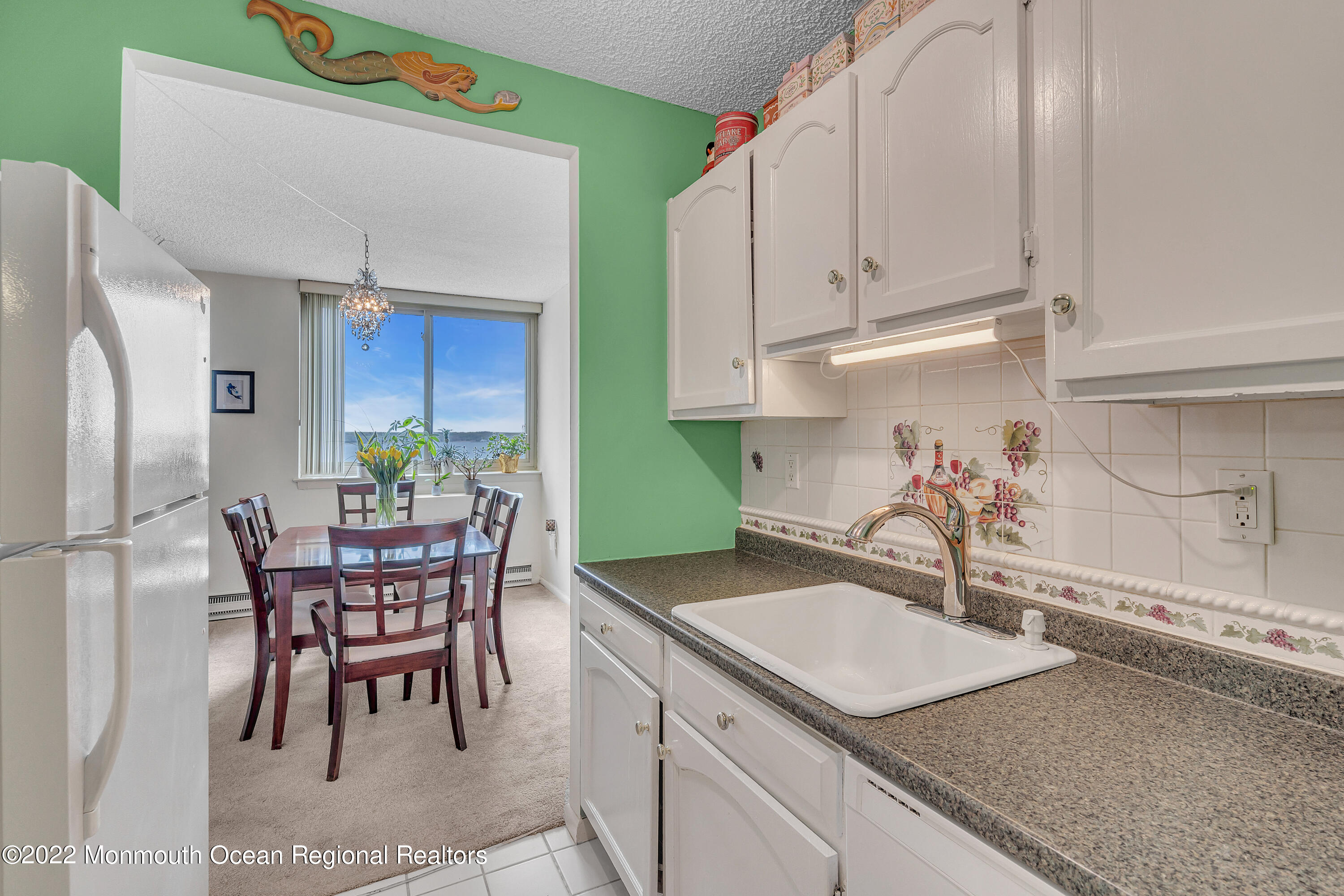 1000 River Road, Unit 7B Belmar, NJ 07719 - Photo 7 of 38 a kitchen with a sink a table and chairs