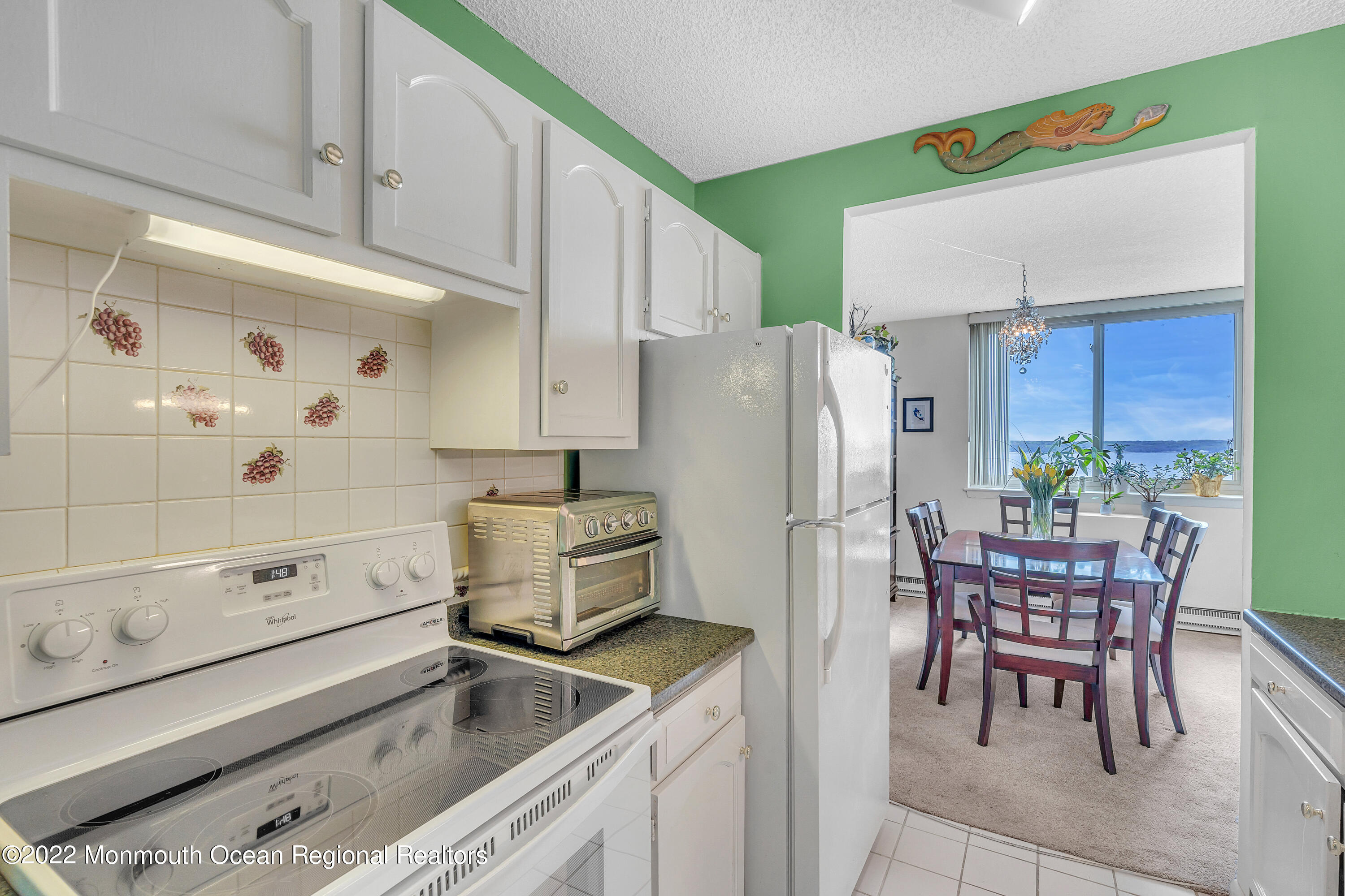 1000 River Road, Unit 7B Belmar, NJ 07719 - Photo 8 of 38 a kitchen with a refrigerator a white table and chairs