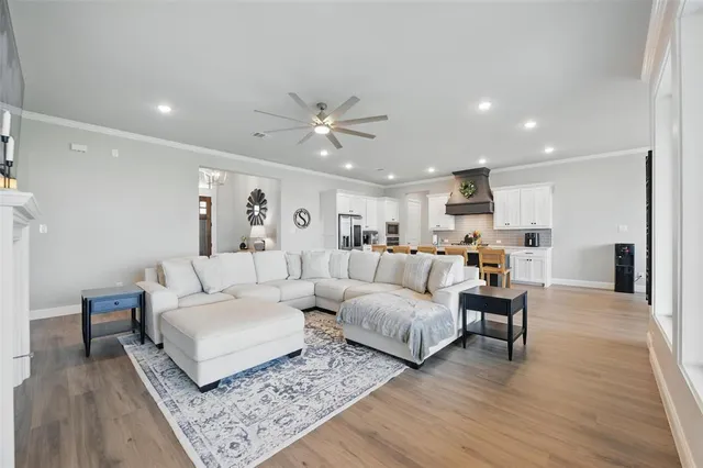 a living room with furniture and a large window with kitchen view