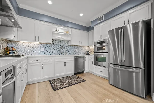 a kitchen with white cabinets and sink