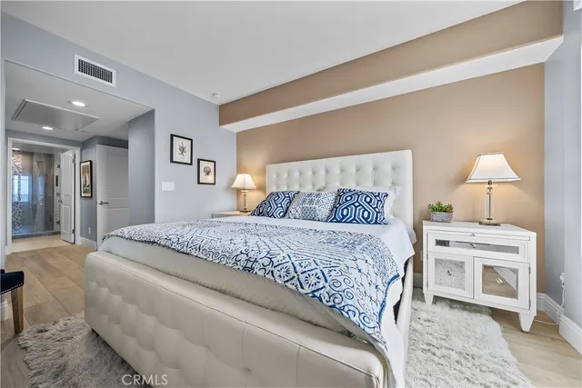 a bedroom with a bed and wooden floor