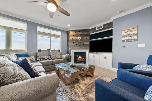 a living room with furniture kitchen view and a chandelier