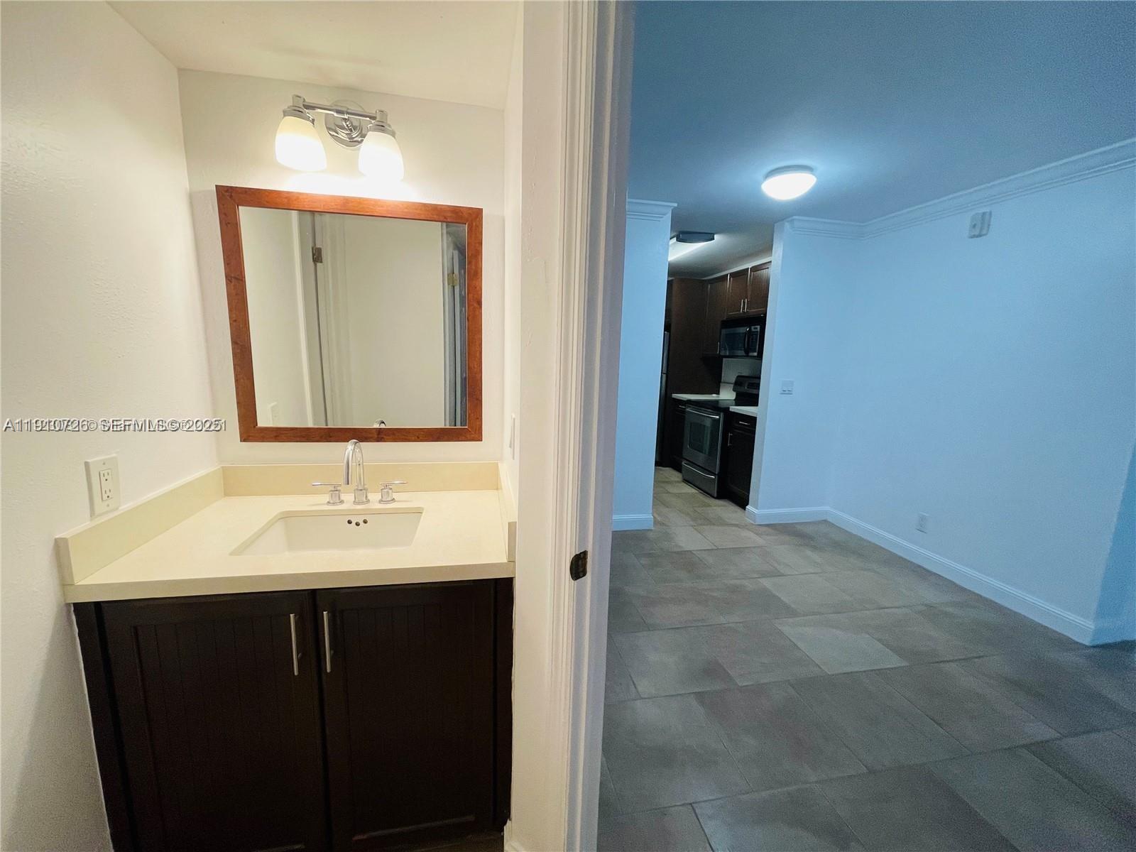 4086 North Pine Island Road, Unit 508 Sunrise, FL 33351 - Photo 12 of 13 a en suite bathroom with a sink and mirror