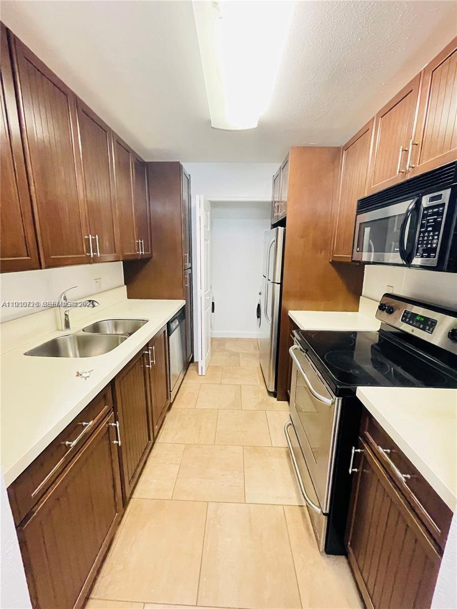 4086 North Pine Island Road, Unit 508 Sunrise, FL 33351 - Photo 4 of 13 a kitchen that has a sink and a stove