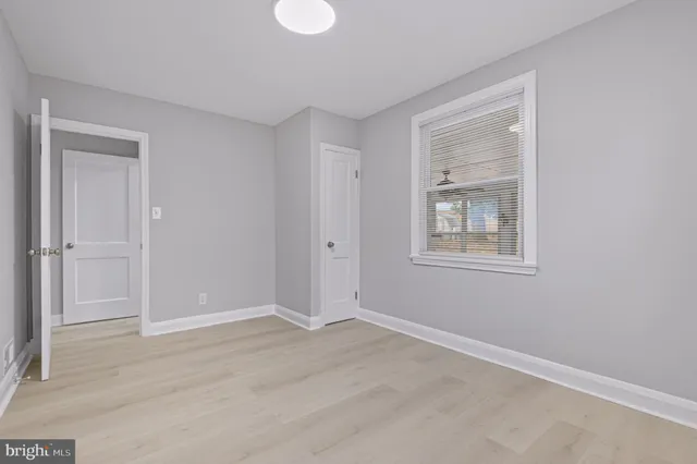 a view of an empty room with closet and a window