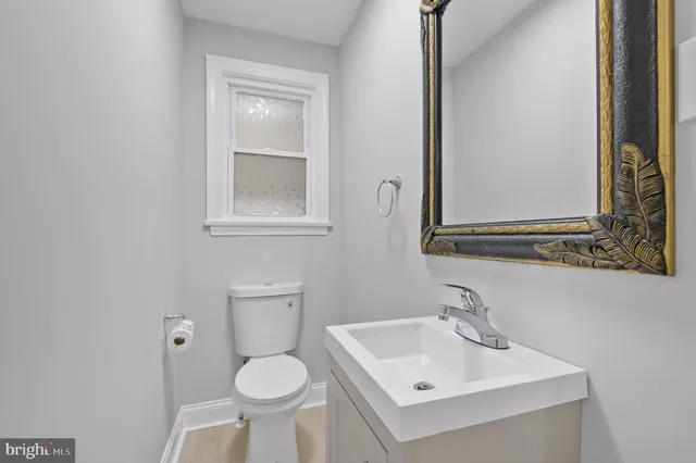 a bathroom with a toilet sink and mirror