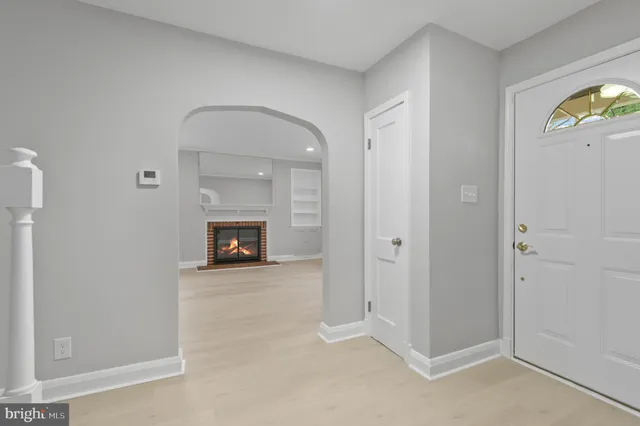 a view of an empty room with a fireplace and a window
