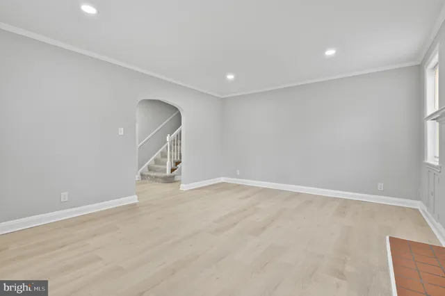 a view of an empty room with wooden floor and entryway