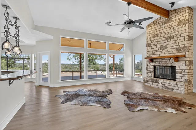 a living room with furniture large window and a fireplace