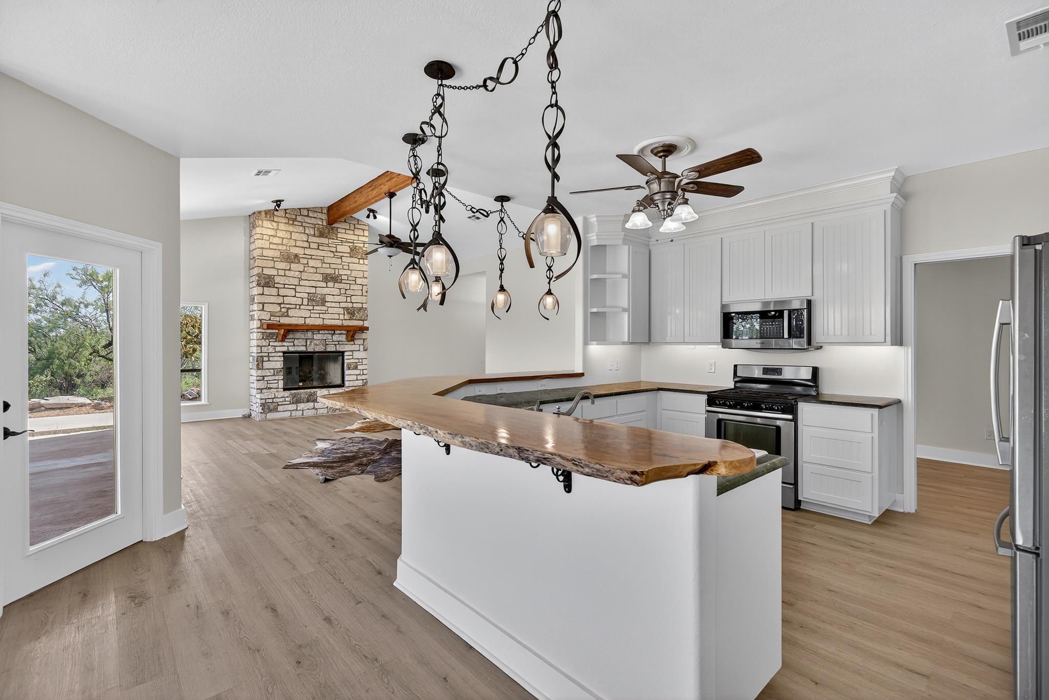 95 Gateway North Marble Falls, TX 78654 - Photo 8 of 30 a kitchen with stainless steel appliances granite countertop a sink dishwasher and a stove with wooden floor