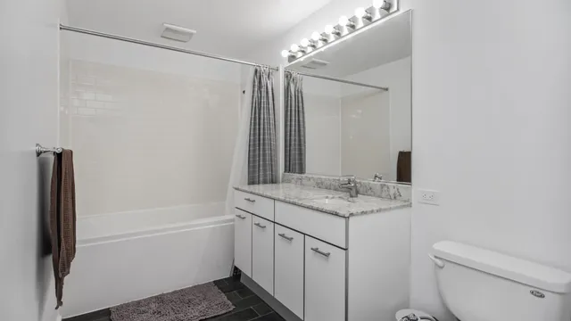 a bathroom with a granite countertop sink toilet and shower