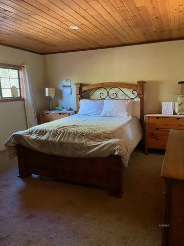 a bed sitting in a bedroom next to a window