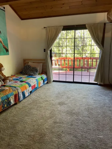 a bed sitting in a bedroom next to a window