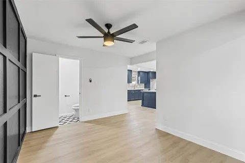 a view of a room with a ceiling fan and window