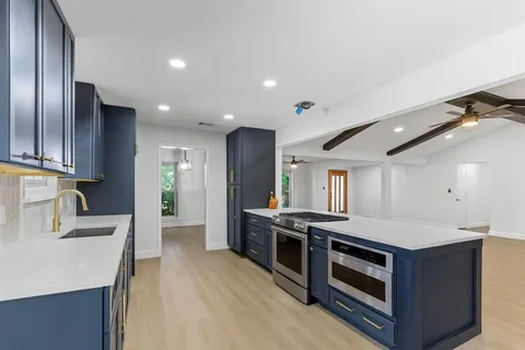 a kitchen with stainless steel appliances granite countertop a stove a sink and a refrigerator
