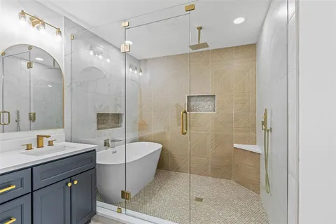 a bathroom with a sink a toilet a mirror and shower