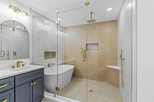 a bathroom with a sink a toilet a mirror and shower