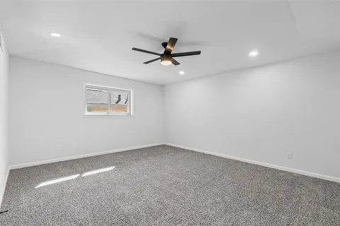a view of a room with a ceiling fan and window