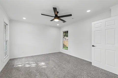 an empty room with window and ceiling fan