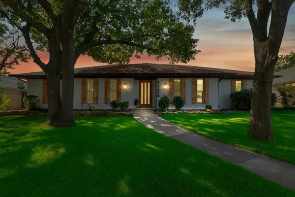 a front view of a house with a garden and yard