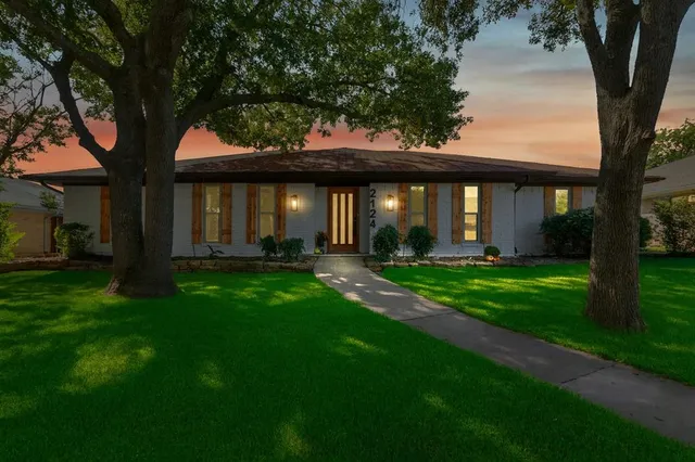 a front view of a house with a garden and yard