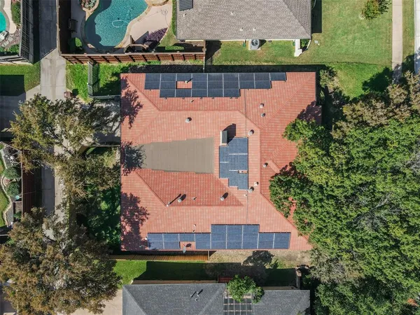 an aerial view of a house with a yard and large tree