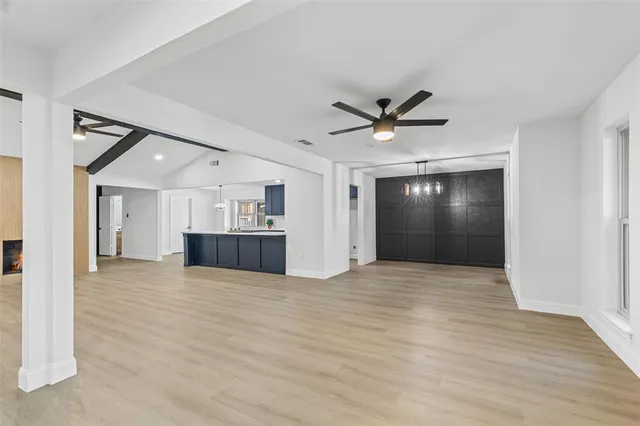 a view of an empty room with cabinet and a ceiling fan