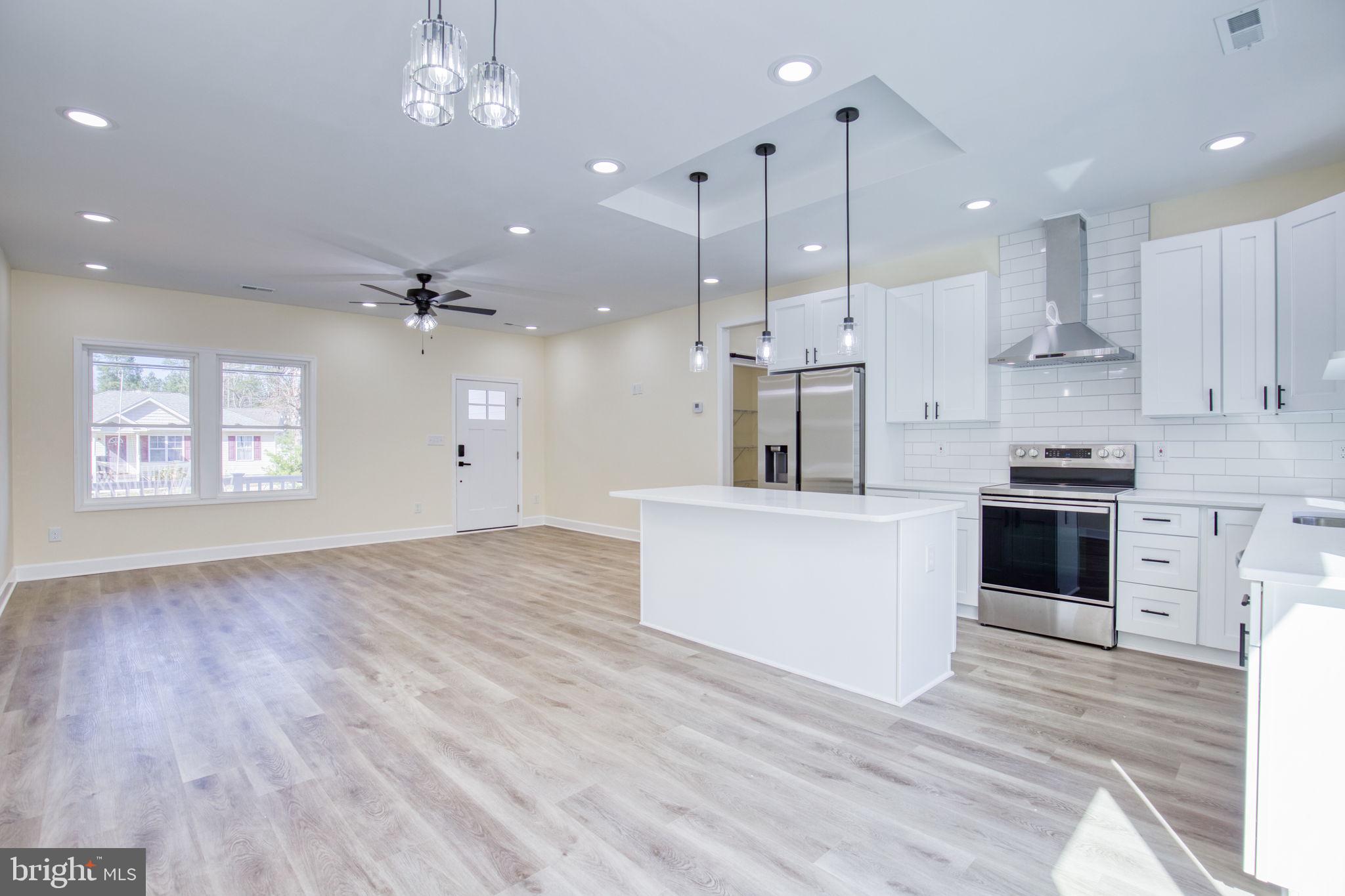 49 Poplar Lane Colonial Beach, VA 22443 - Photo 12 of 42 a large kitchen with kitchen island a stove a sink a center island and wooden floor