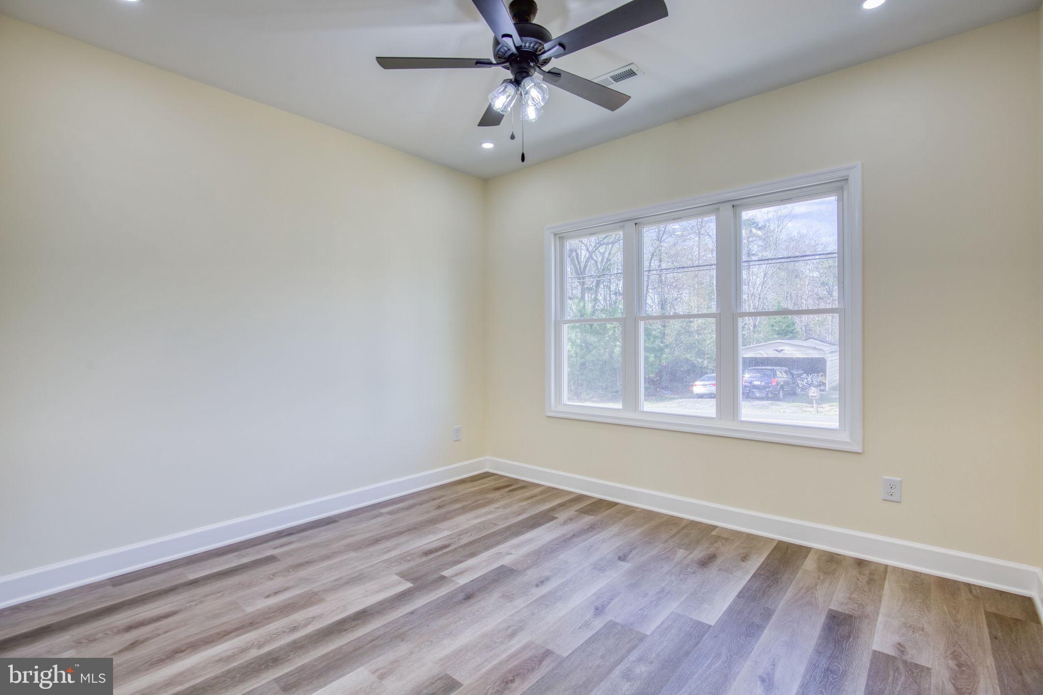49 Poplar Lane Colonial Beach, VA 22443 - Photo 28 of 42 an empty room with wooden floor chandelier fan and windows
