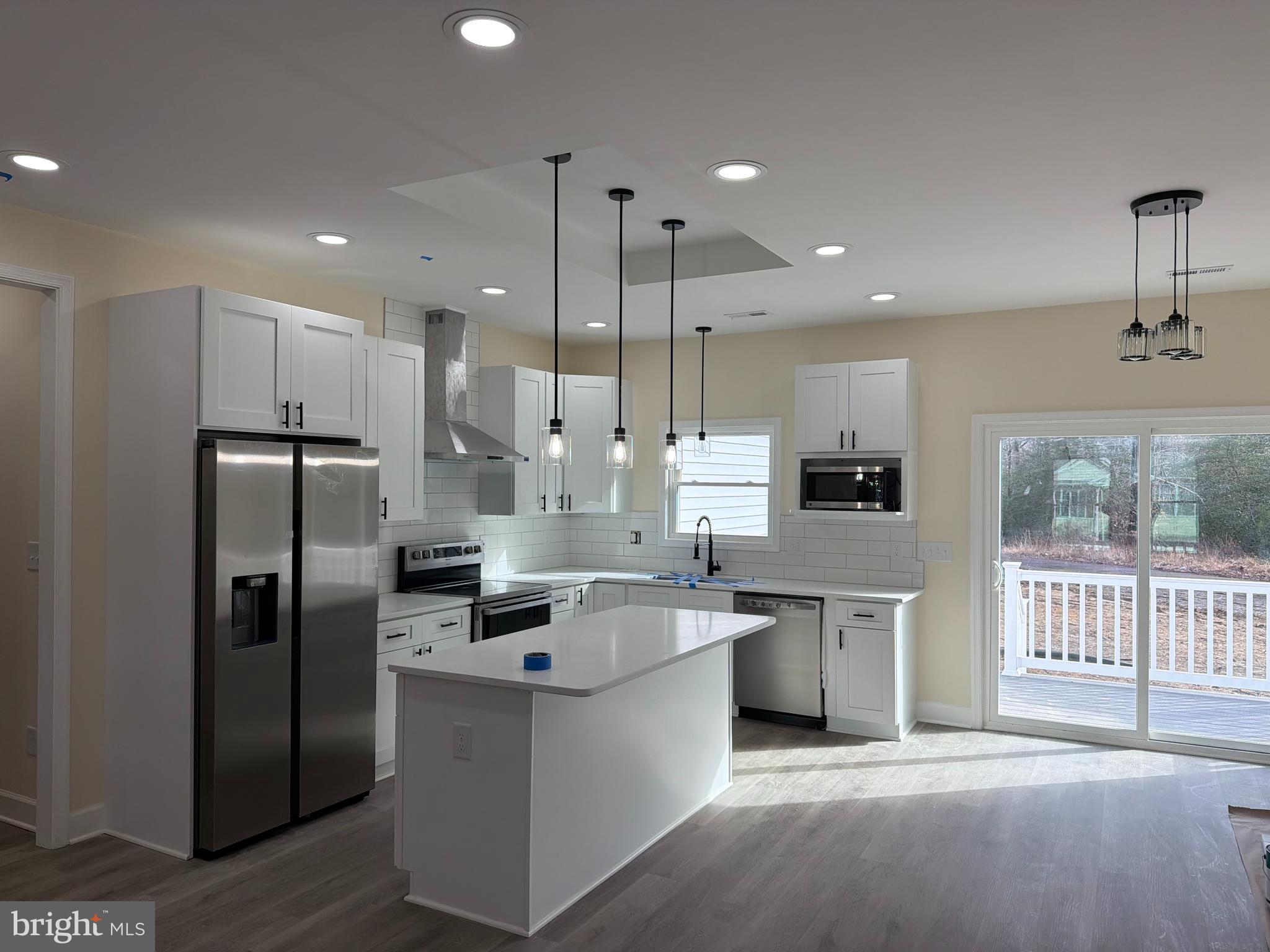 49 Poplar Lane Colonial Beach, VA 22443 - Photo 4 of 9 a kitchen with stainless steel appliances granite countertop a refrigerator a sink a stove and a oven