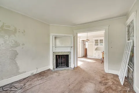 an empty room with fireplace and a window