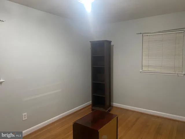 an empty room with wooden floor and closet