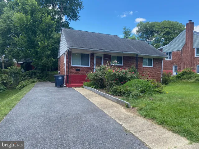 a front view of a house with yard and green space
