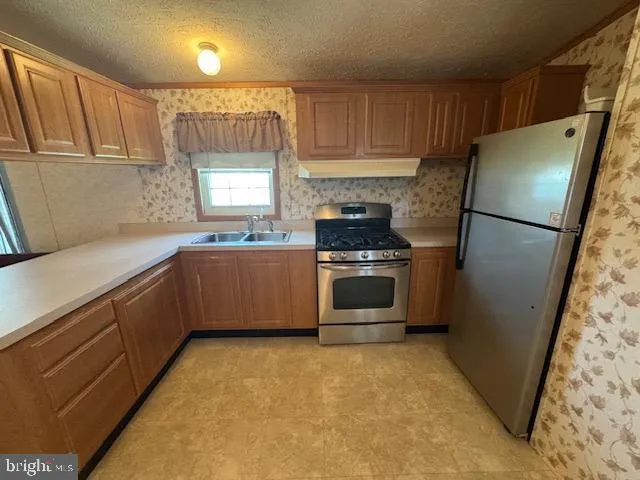 a kitchen with stainless steel appliances a refrigerator sink and cabinets