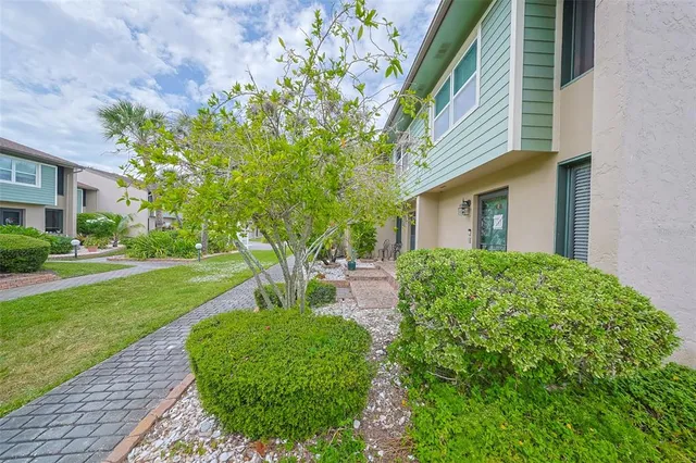 a front view of a house with fountain and garden