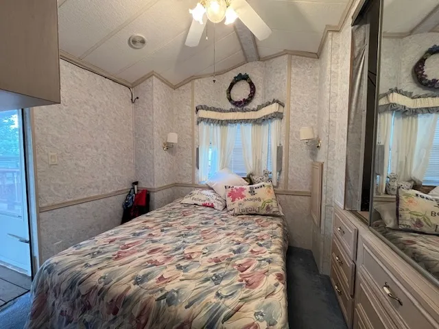 a bedroom with a bed and a large mirror on the dresser