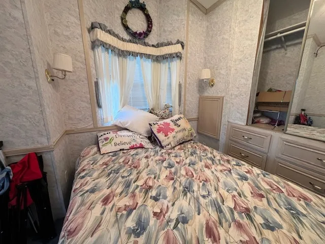 a bedroom with a bed and a flat screen tv