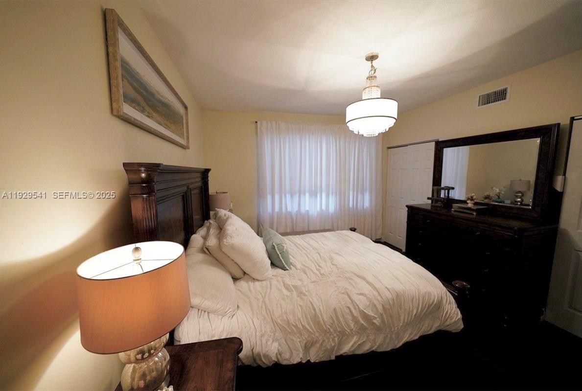 171 Southwest 96th Avenue Plantation, FL 33324 - Photo 18 of 24 a bedroom with a bed and a chandelier