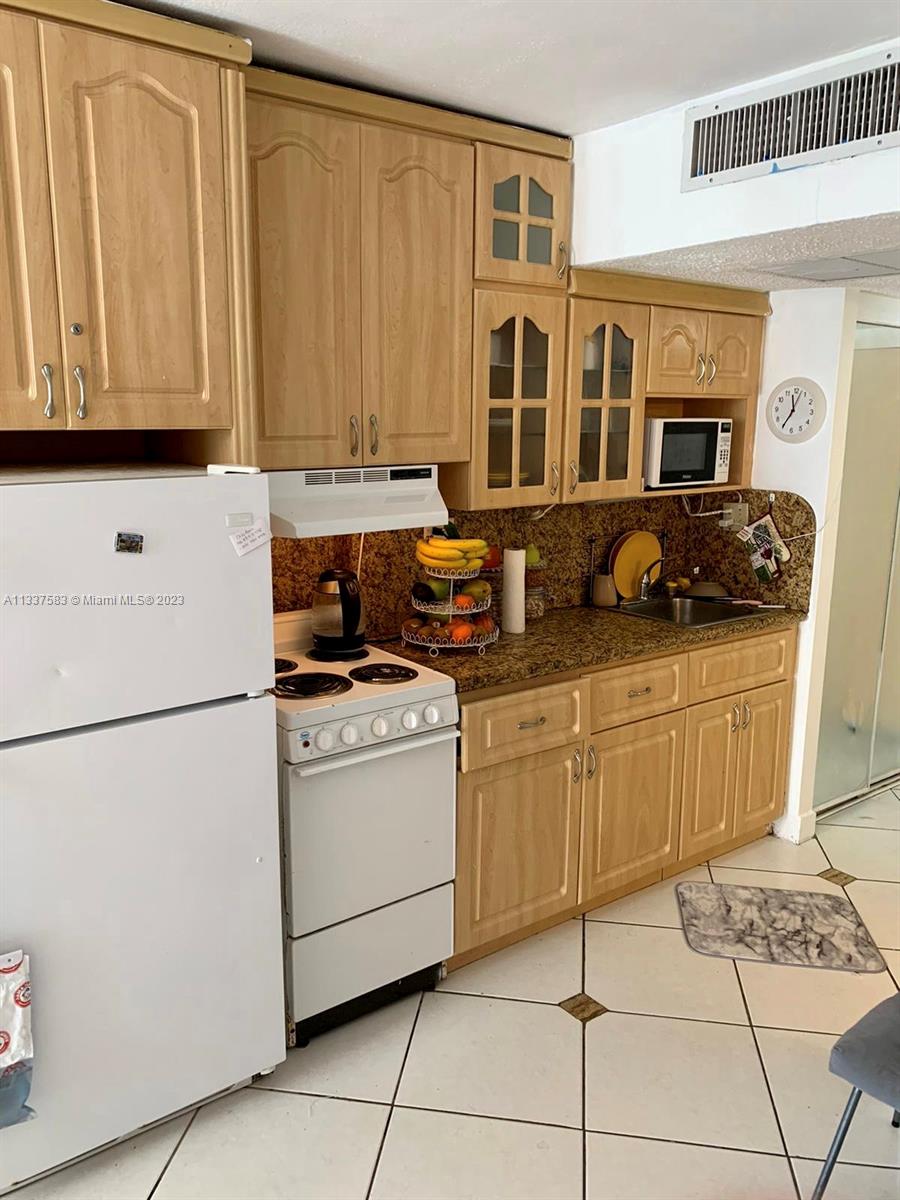19201 Collins Avenue, Unit 906 Sunny Isles Beach, FL 33160 - Photo 7 of 19 a kitchen with stainless steel appliances granite countertop a stove a sink and a refrigerator