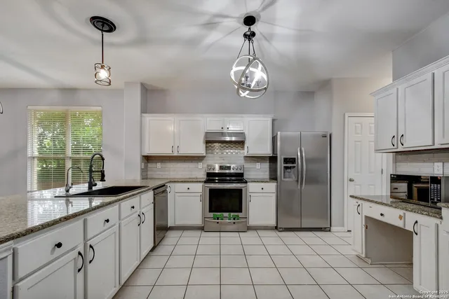 a large kitchen with stainless steel appliances granite countertop a stove and a refrigerator