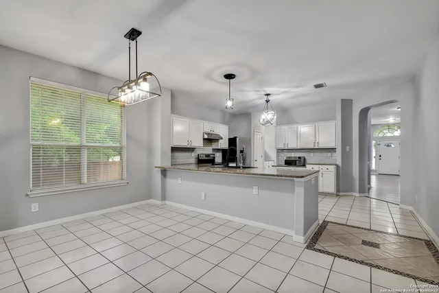 a kitchen with stainless steel appliances granite countertop a sink and a refrigerator
