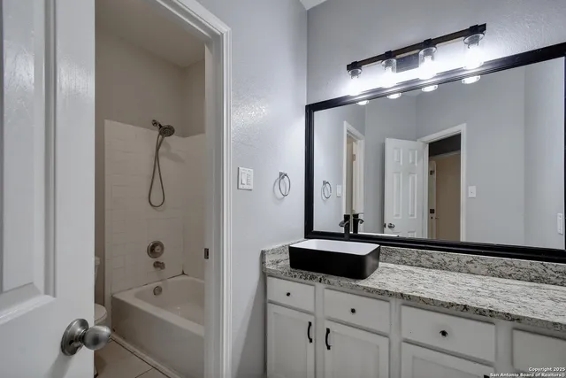 a bathroom with a tub a sink and mirror