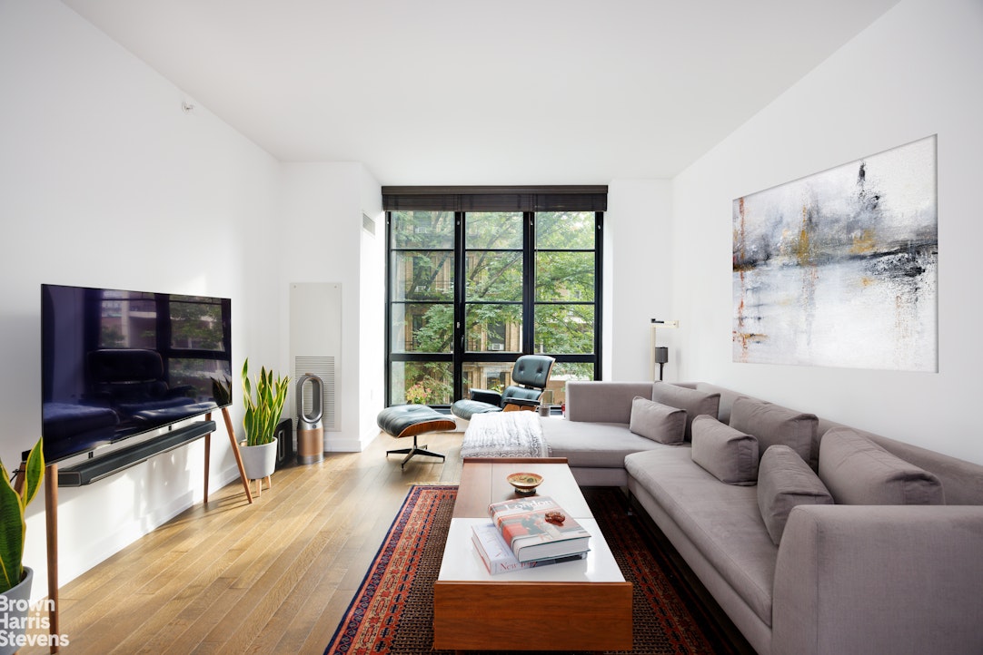 261 West 25th Street, Unit 4B Manhattan, NY 10001 - Photo 1 of 15 a living room with furniture and a flat screen tv